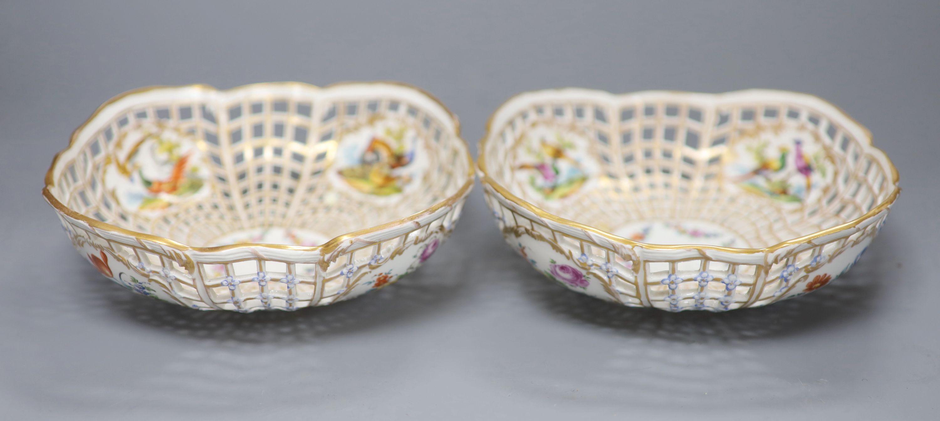 A pair of fine Continental pierced baskets, the panels painted with birds or flowers inside and out, blue Berlin style mark